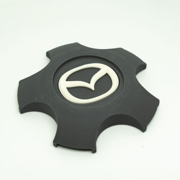 Tapabujes Mazda 6 color gris logo blanco. 4 unidades